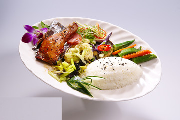 Scallions pork rice, grilled chicken with vegetable on white pla