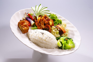 Chicken rice with tofu and cabbage, broccoli on white plate in w