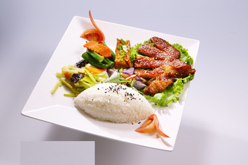 Braised ribs rice with vegetable on white plate in white backgro
