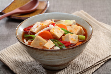 Cheese tofu stew soup on bowl on tablecloth in restaurant