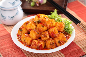 Mapo tofu with lettuce and tea pot on white plate on bamboo tray