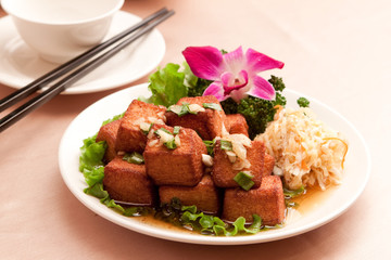 Fried tofu with lettuce and salad on white plate