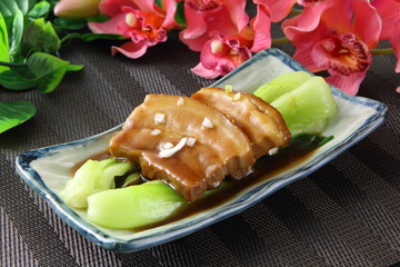 Braised pork meat with cabbage on plate in restaurant