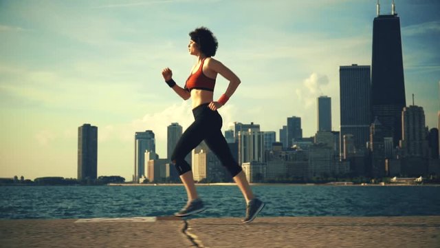 Runner athlete running at seaside with skyscrapers on the background