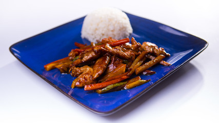 Chicken teriyaki on blue chinese plate on white background