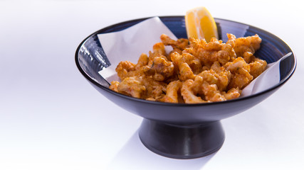 Fried ring octopus with lemon in blue chinese bowl on white back