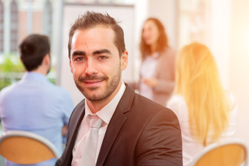 Young attractive businessman working at the office with associat