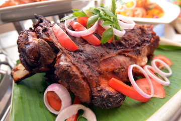 The whole roasted lamb with chili, onion and herbs on banana lea