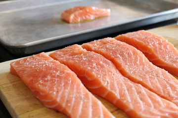 Sliced of fresh red salmon on wooden cutting board