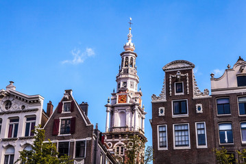 AMSTERDAM, NETHERLANDS - AUGUST 6, 2016: Famous buildings of Amsterdam city centre close-up. General landscape view of city streets and traditional Dutch architecture. Amsterdam - Netherlands.