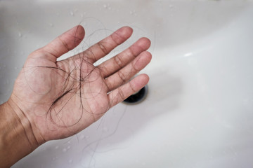 Close-up a man hand with loss hair, after taking shower, concepts of loosing hair