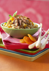 Veal risotto with lemon grass on green bowl and tablecloth