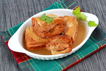 Gold bar soup as fried tofu wrap minced pork in soup and coriander . Side view.