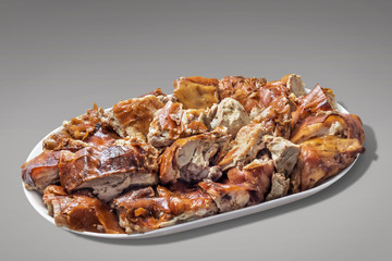 Plateful of Spit Roasted Pork Cut in Slices On Gray Background