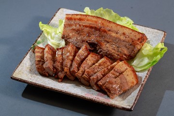 The plate of Hakka dishes pepper bacon with lettuce on grey back