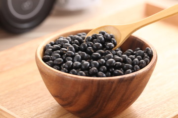 Black beans in wooden bowl on the table