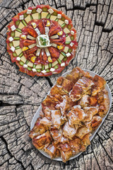 Plateful of Spit Roasted Pork Slices And Appetizer Savoury Dish Meze On Old Wooden Picnic Table