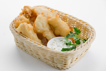 Cod in beer batter with tartar sauce in bamboo basket on white b