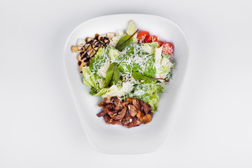 Caesar salad with Peking duck, lettuce and herbs on white plate