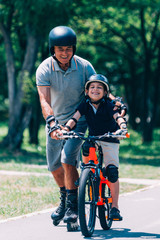 Obraz premium Grandfather and grandson have fun roller skating and biking