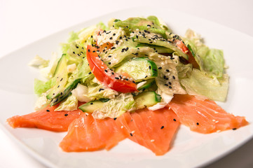 Salad with salted salmon, tomatoes and cucumbers on a green cush