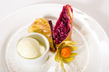 Strudel of frozen puff pastry with cherry on white plate