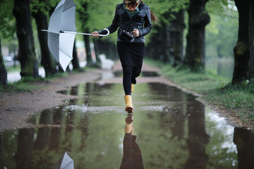autumn landscape city woman umbrella rain puddles of yellow trees - obrazy, fototapety, plakaty