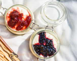 Jars Of No Bake Cheesecake With Blueberry And Strawberry Jam