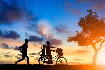 Fototapeta premium Silhouette children as well as running, cycling friends playfull