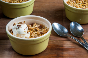 Freshly made autumn apple crumble with fresh green apples on a wooden table, top view