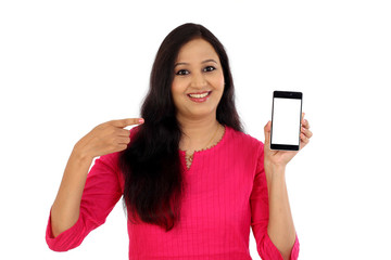 Fototapeta premium Happy young woman holding mobile photne against whtie background