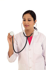 Female doctor with a stethoscope listening against white backgro