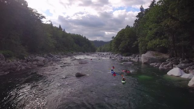 Aerial Shot with Group of People in Kayaks Paddling Down Forest River