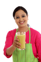 Happy female chef holding glass of avocado smoothie against whit