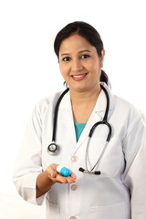 Young female doctor holding up a pill