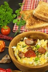 Scrambled eggs with fried bacon. English breakfast. Toast and scrambled eggs with chives. Recipe for a healthy meal.
