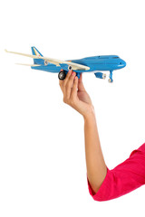 Woman hand holding toy plane against white background