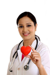 Happy young female doctor holding a beautiful red heart shape