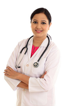 Young female doctor with arms crossed against white background