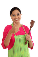 Happy young woman holding kitchen utensil against white backgrou