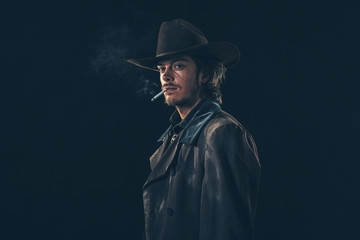 Retro cowboy smoking cigarette. Young man. Studio shot.