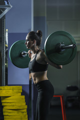 Fototapeta na wymiar Concept: power, strength, healthy lifestyle, sport. Powerful attractive muscular woman CrossFit trainer do workout with barbell at the gym