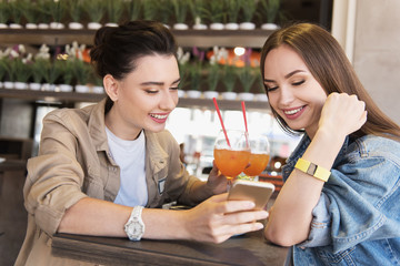 girl showing her phone to sister