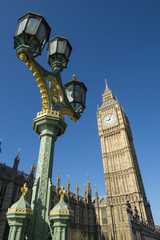 Fototapeta na wymiar Big Ben shines in bright morning sun behind a decorative lamppost at Westminster Palace London