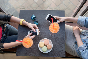 hands of girls with phones in a cafe