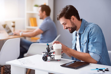 Cheerful man testing robot