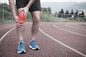 Fototapeta na wymiar Runner with injured knee on the track