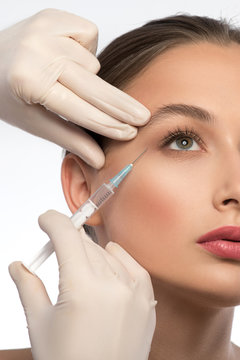 Experienced beautician injecting woman face