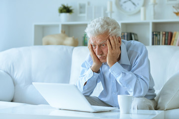 Fototapeta premium senior man at home with laptop