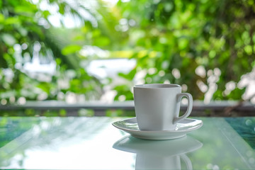 White coffee cup glass  floor with green blurred background.